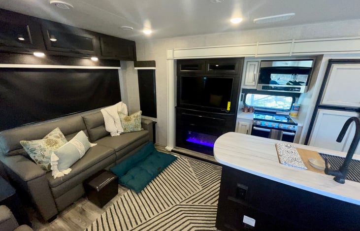 Spacious, comfortable living area with sound system and atmospheric glass fireplace