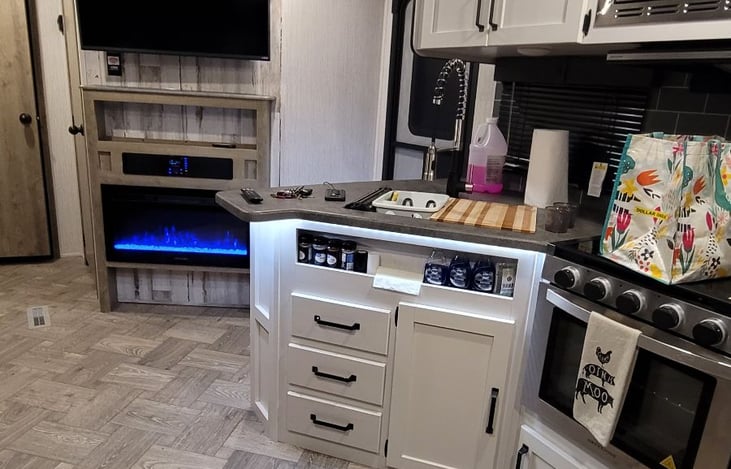 Kitchen with gas range microwave , larger fridge, pantry.  Fireplace radiates heat.  Radio with bluetooth.   TV and even a wifi router and booster as well