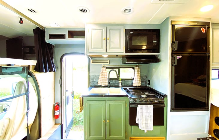 Open view of our RV interior — full kitchen, bed, and lounge area for a perfect road trip rental.