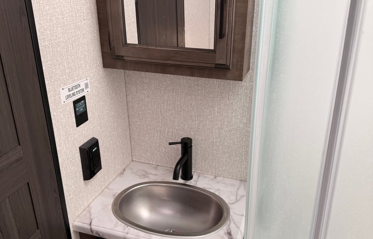 Main bathroom with sink, shower, and porcelain toilet.