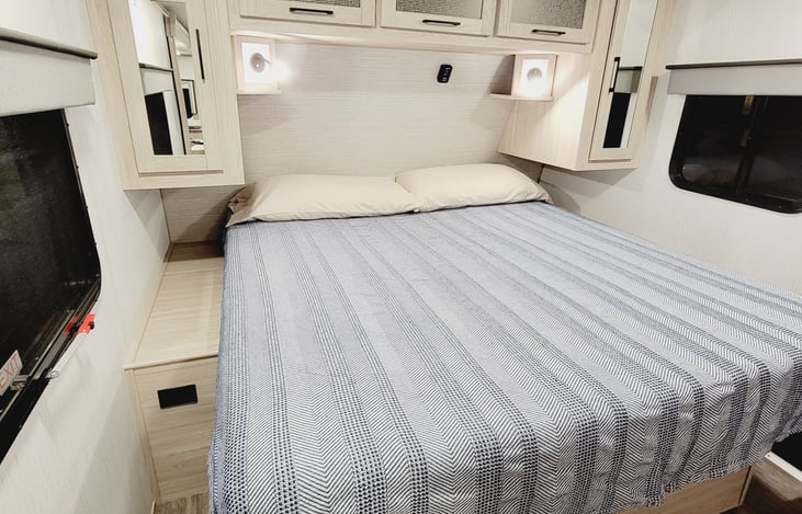 Bedroom with king size bed and lots of upper and side storage.