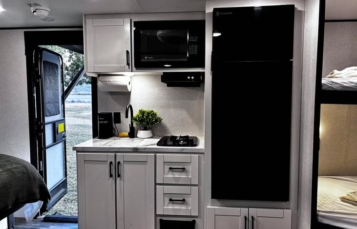 A bright, modern kitchenette stocked with essentials and featuring a Keurig coffee maker with complimentary coffee for an easy, comfortable start to your day.