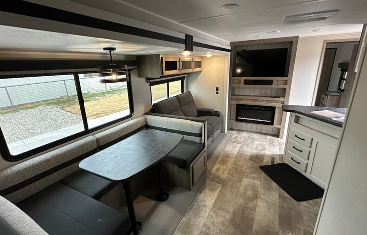 Living room and kitchen with electric fireplace and LED TV.
