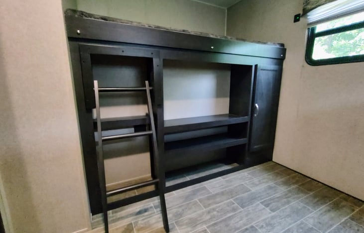 Bunk bed located across from the other bunks. This is over the outside kitchen, so there is only some storage below bunk from inside the camper.