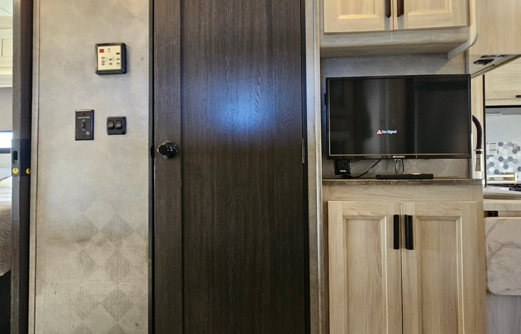 view into master bedroom view, bathroom door and TV