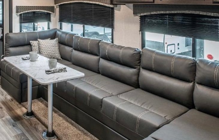 Unique, super sofa that seats six in front of indoor entertainment center and fireplace.
