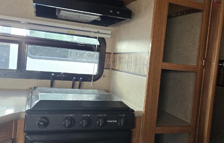 3 burner propane stove with oven and overhead microwave. Lots of storage space here too!