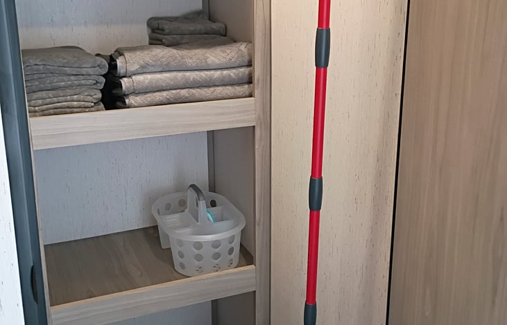 LInen closet full with towels and cleaning supplies.