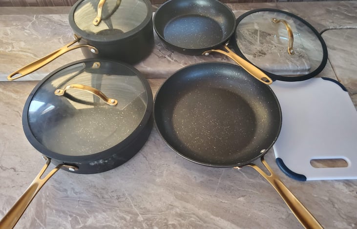 Pots, pans, and a cutting board are included.