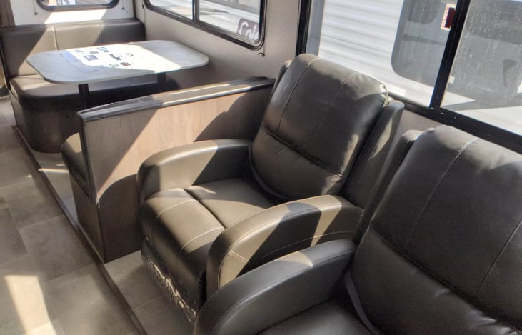 Recliners and table that folds down into a bed.