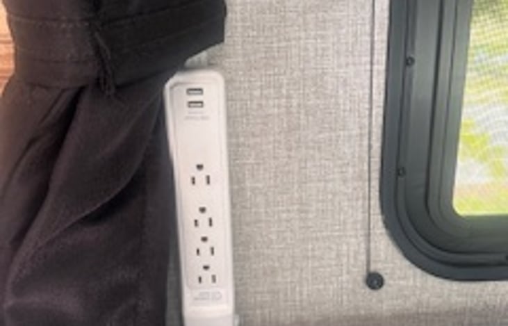 Added power strip next to main bed for easier access to charging electronics.