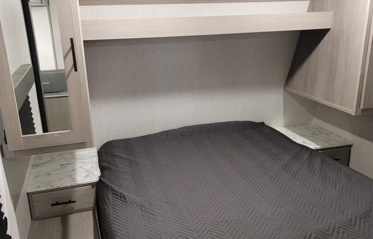 Main bedroom with a queen size bed. Storage shelves and drawers as well on each side.