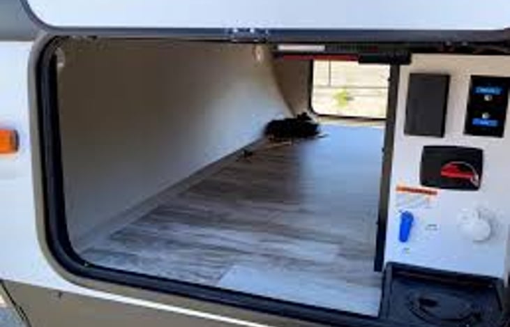 Pass through storage. Shown empty, but we've filled it with chairs, rug, necessary hoses and cables, and tools. The outside control panel is very handy.