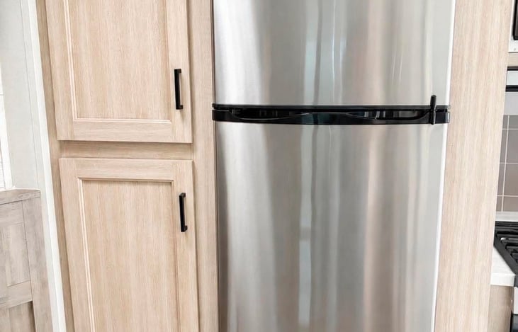 Spacious refrigerator with separate freezer and convenient cabinetry for additional kitchen storage.