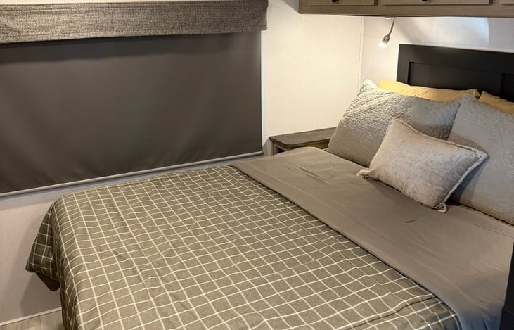 Master Bedroom with queen bed & upper storage with personal reading lights and bedside table/storage