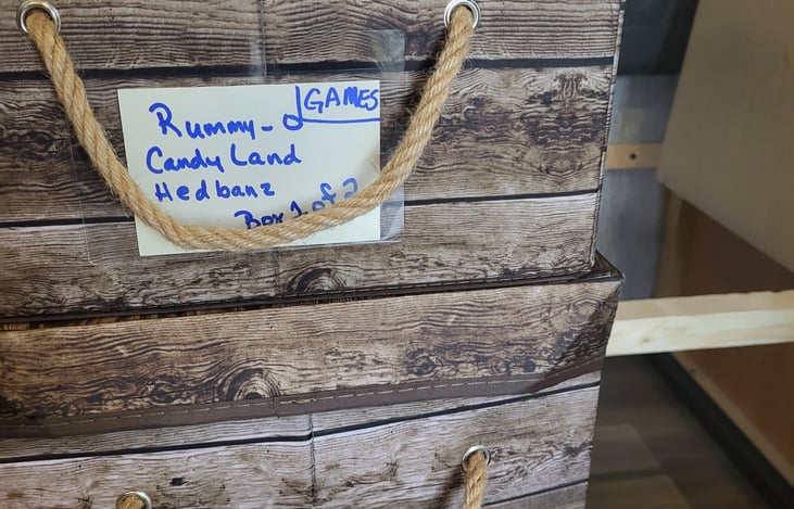 Under dinette storage showing game bins.