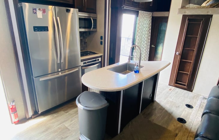 Full size residential refrigerator. Convection microwave and gas stove. Sliding door goes out to porch and additional TV.