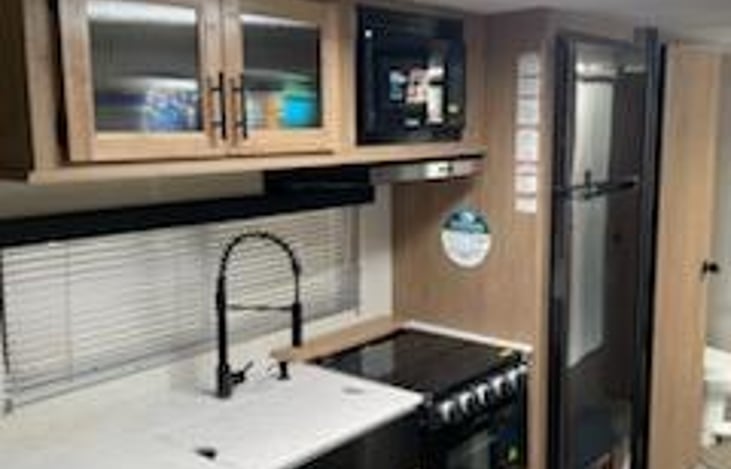 Kitchen with full size refrigerator and freezer.  Stove and oven. Microwave. Also equipped with Keurig coffeemaker and toaster, pots, pans and utensils.