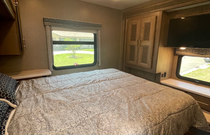 Spacious master suite with queen size bed, TV, Bluetooth stereo, and entry into the bathroom
