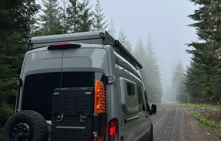 Adventure-ready from every angle—the back of the van features a full-size spare tire, Owl Vans XL Expedition Box for extra storage, and bright orange traction boards to keep you moving through sand, m