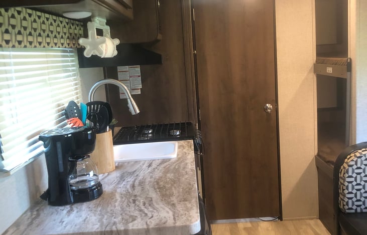 View from the entrance door looking towards the kitchen, bunk beds to the right, pantry on the left, and bathroom straight ahead