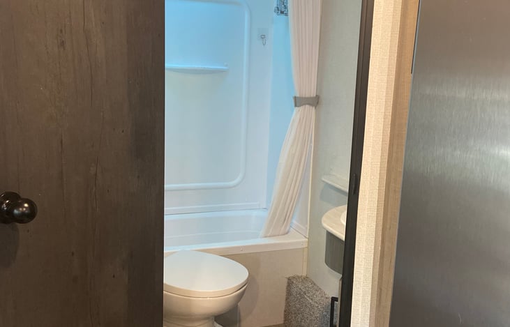 Bathroom with shower/tub, sink, mirror and toilet.