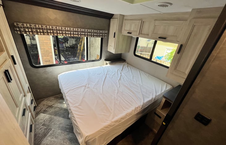 Master bedroom with short queen bed and mattress cover. Plenty of cabinet space.