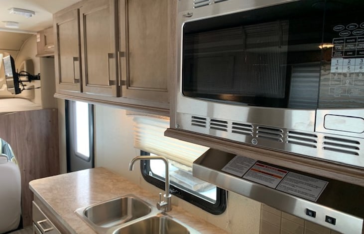 The spacious kitchen has three burner stove, microwave oven, and refrigerator. Included are plates, bowls, glasses, flatware, and pots &pans.