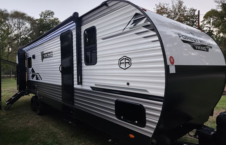 Exterior with 2 doors. 1 door to bathroom and 1 to living area. Awning with lights