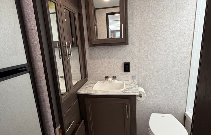 Dedicated bathroom vanity with mirrored medicine cabinet, sink, and under-sink storage.
