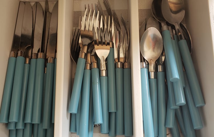 silverware in drawers of sink