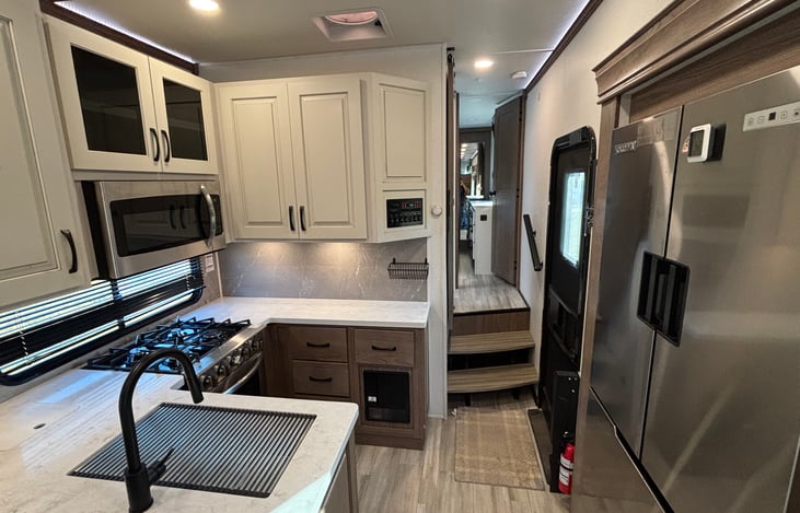 Kitchen area, lots of prep space, full sized fridge, four burner stovetop, oven, and microwave