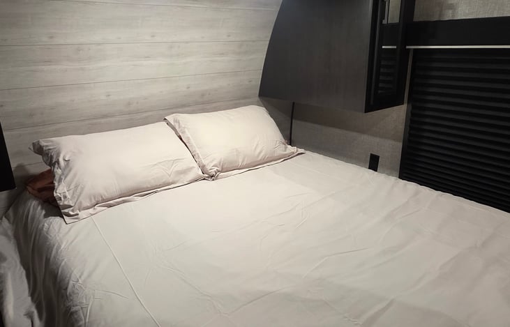 Queen size bed towards the front of the camper