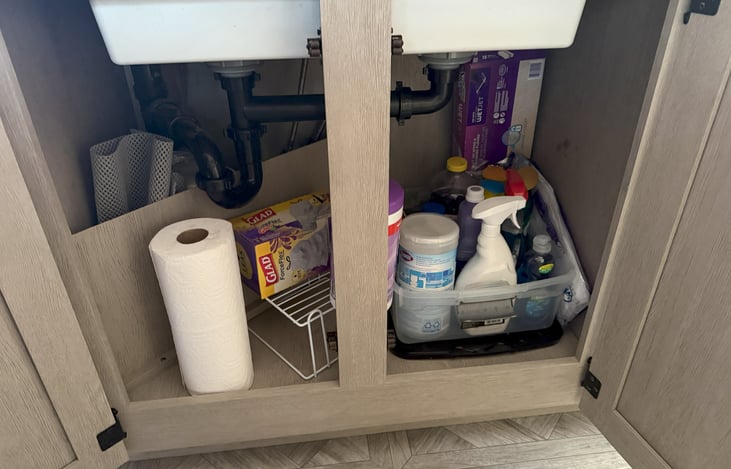 Cleaning supplies and trash bags under the kitchen sink.