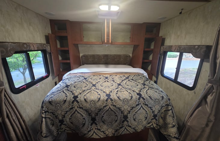 Queen bed with shelved closet space on each side.
