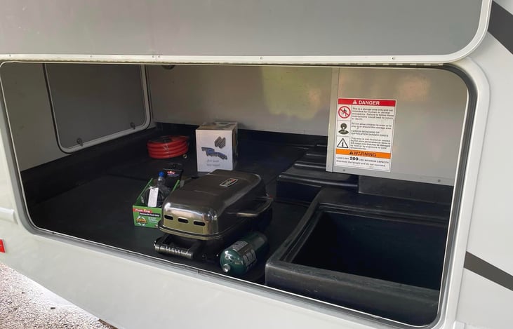 Outside storage has ample luggage space, a spare table, water and sewer hoses, and a tabletop grill can also be included.