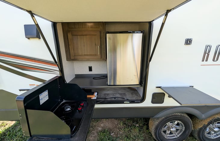 Features a convenient outdoor kitchen with a mini-fridge, 2-burner gas cooktop, and storage! Perfect for cooking outside under the 21-ft awning.