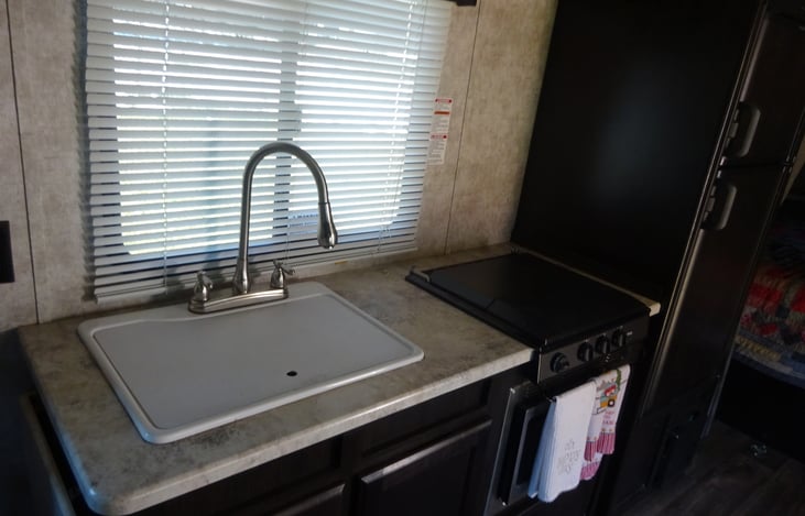 Full size sink with four burner stove and microwave