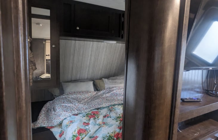 Queen bed up front with 2 sliding doors.