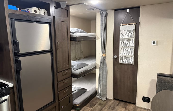 Triple bunk with linens and pillows provided. Curtain for additional privacy.