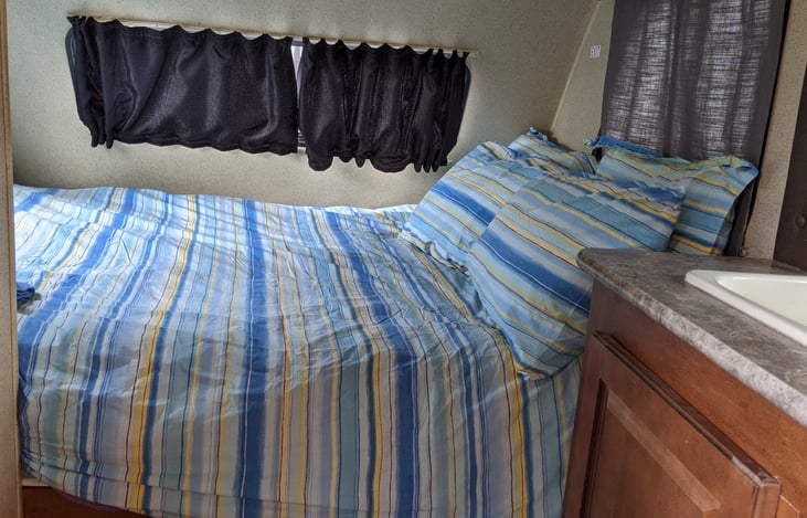 Queen-size bed with freshly cleaned linens and towels.