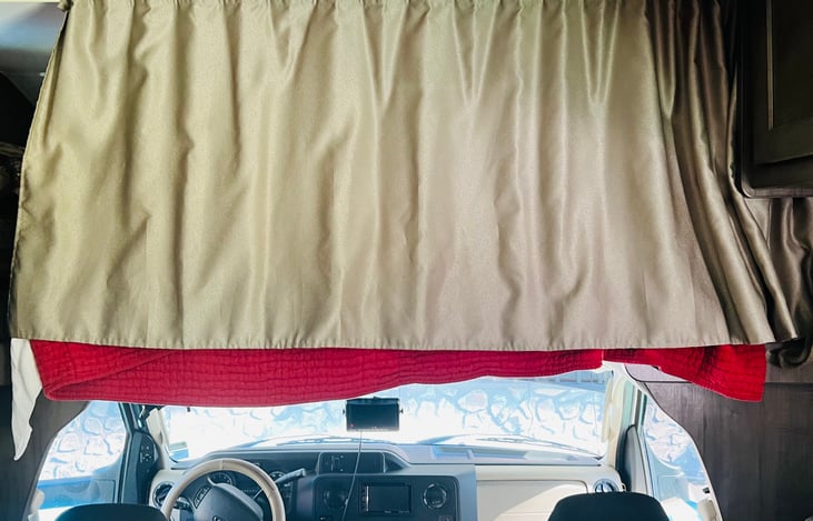 Bed above driver and passenger seats