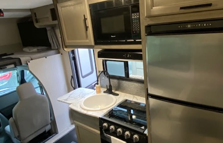 Kitchen.  3 burner gas stove, oven, sink, and spacious RV fridge/freezer