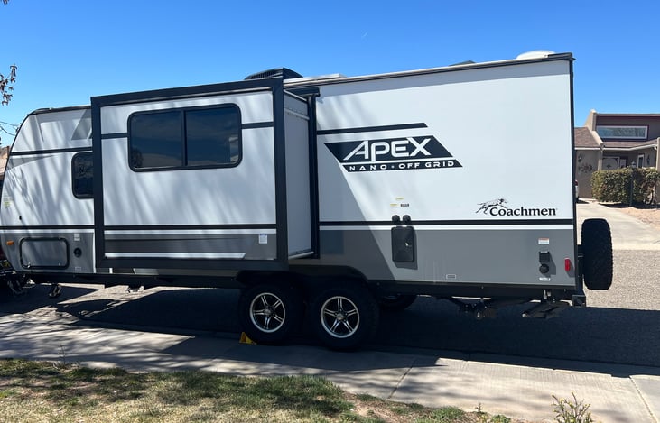 On the left side of the travel trailer, you will find the door to the outdoor shower, slide out and electrical outlet.