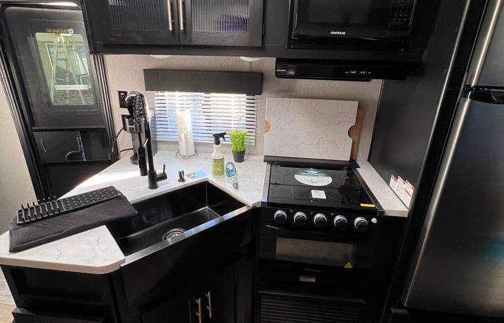 Kitchen with sink open and drying rack for dishes
