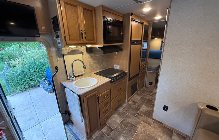 Kitchen has a 3 burner LP stove, convection microwave, sink & fridge with freezer. 
Microwave can be run with shore power or generator