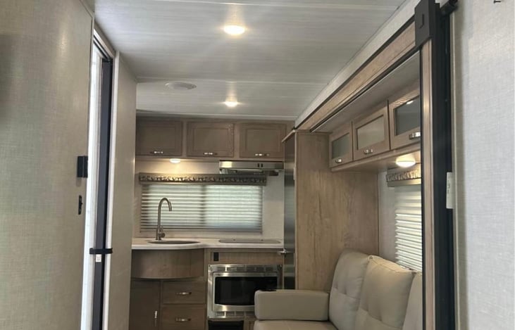 sink , stove , microwave, fold out couch