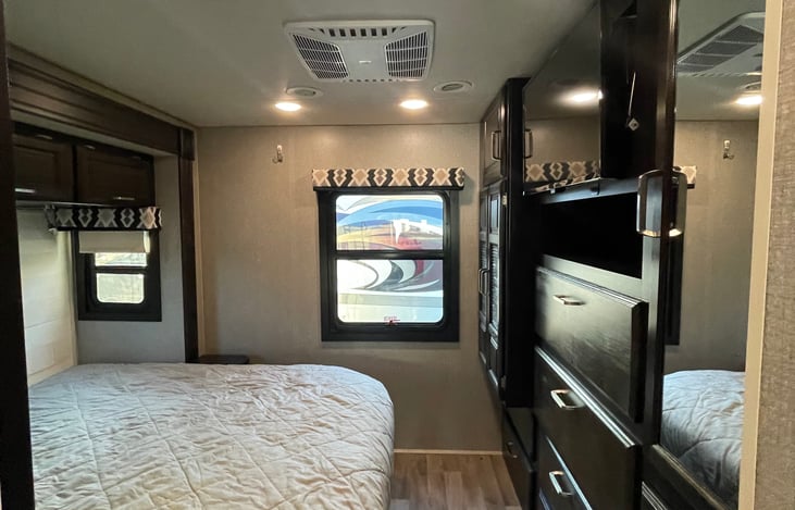 Master bedroom with dresser. There is a washer/dryer all in one unit towards the left hand size of the room.