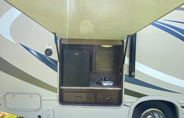 Outdoor kitchen with running water sink and fridge, use our grill and table for an outdoor picnic under the awning