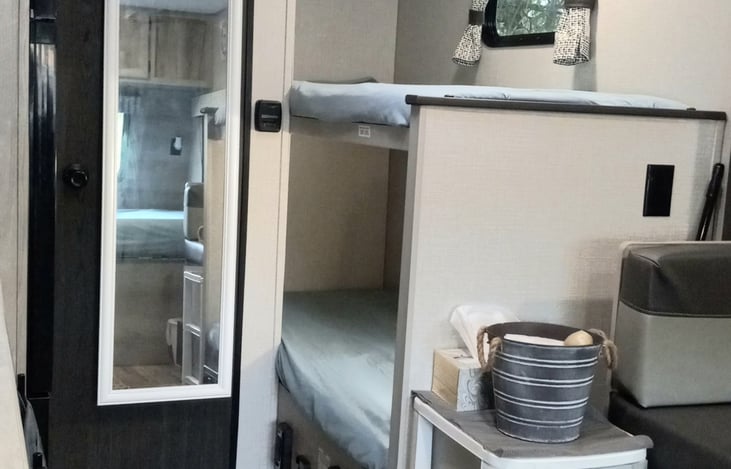 There are two Bunk Beds, that comfortably sleep another two people, for an overall RV sleep space of six. Each bunk bed space has a window and a light